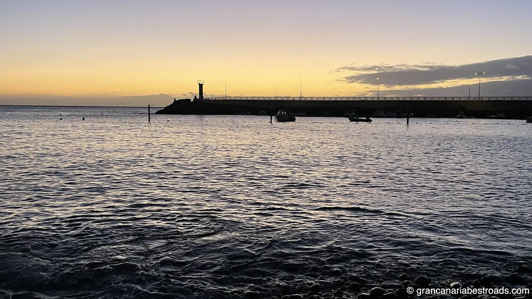Der Strand und der Pier von La Aldea, mit Teneriffa im Hintergrund